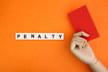wooden hand holding a red card with the word penalty alphabet letters. fined concept