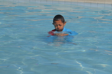 boys and girls practice swimming and playing in water
