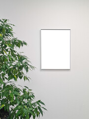 Blank white picture frame mockup and green leaves on white background / Flat lay / top view / copy space