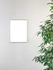 Blank white picture frame mockup and green leaves on white background / Flat lay / top view / copy space