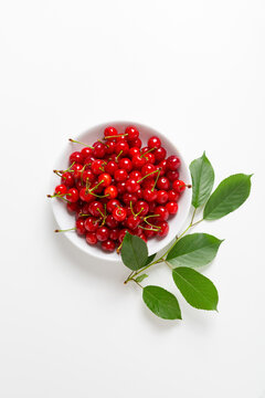 Overhead View Of Ripe Sour Cherry In Bowl Twig On Light Surface