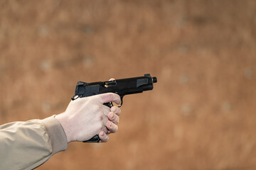 M1911 pistol in the hands of the shooter during the shot and recoil.