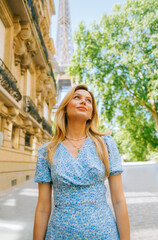 Portrait of young attractive woman fashion model posing near Eiffel Tower in Paris .