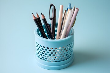 pencils and pens in a penholder, light blue background