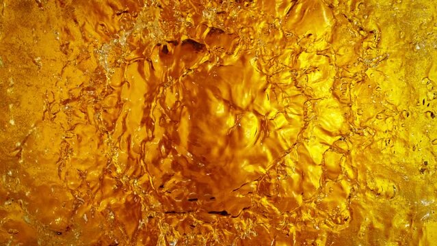Super Slow Motion Shot of Waving Golden Alcohol Liquid Waves at 1000fps.