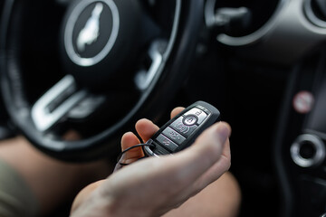 Car key fob holding caucasian hand male auto on off control drive