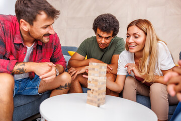 Friends having fun playing removing and stacking balance game