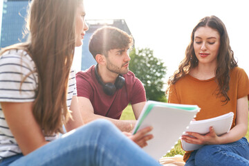 Group of caucasian students sitting outside the university campus