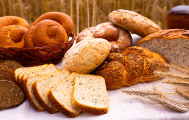 lot of different flavored bread, wheat, rye, on the table in the field outside