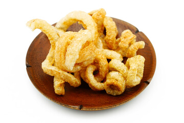 Pork snack or Pork scratching leather lean pork fried crispy and blistered in wood plate isoloated on white background.
