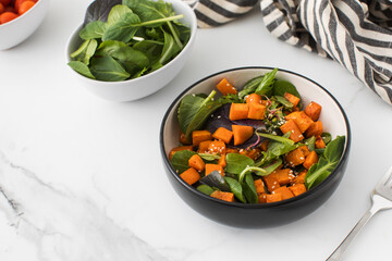  Green salad with sweet potatoes and sesame seeds. Vegan dish. Healthy eating. Copy space