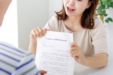 不倫についての書類を見せる女性