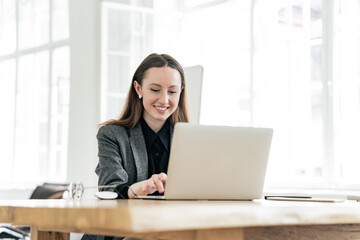 A woman uses a laptop computer workplace employee in the office. Happy man assistant online job.