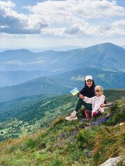 Fototapeta na wymiar Mom and girl hiking on a mountain