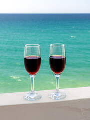 two glasses of wine on the background of the sea surface