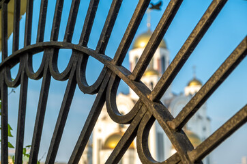 Cast-iron figured lattice on the background of the church.