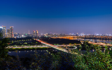 Obraz premium Night cityscape view of Seoul city in South Korea with modern architecture and the light of transportation
