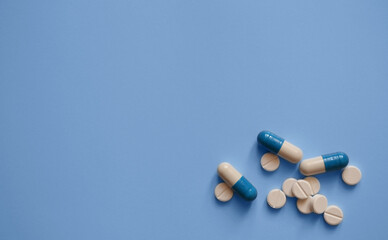 capsules and tablets on a blue background, photos for a medical website, medicines, medical care, a banner for a medical clinic, a place for text