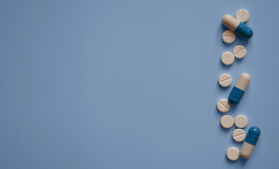 capsules and tablets on a blue background on the right, a photo for a medical website, medicines, medical care, a banner for a medical clinic, a place for text