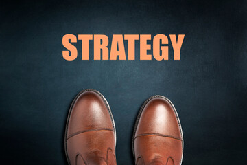 Strategy concept. Men's boots on a dark background. Top view. Business.
