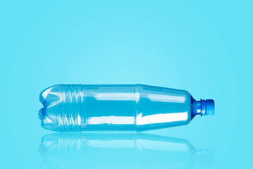 Plastic bottle on a blue background.Reflection. Products, packaging, storage, recycling.