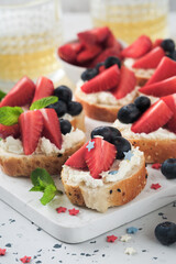 American flag sandwich with strawberries, blueberries, whipped sweet cream, soft cheese on toast bread. 4th of July American Independence Day food. Independence or Patriotic Day breakfast idea Mock up