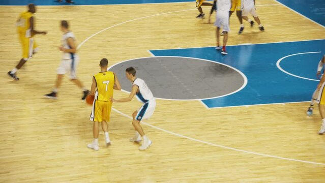 National Basketball Playoffs: Yellow Team Player Passing And Dribbling Past Defense, Basketballer Misses The Shot But Teammate Scores A Rebound. Live TV And Intrernet Playback For Sports Channel