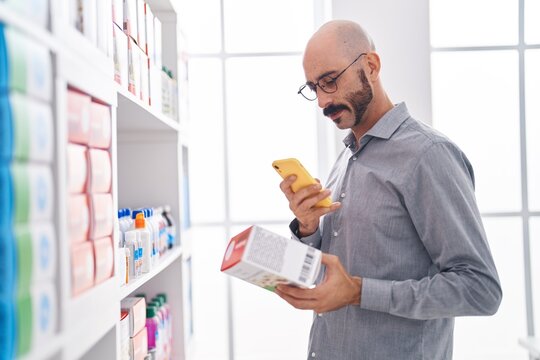 Young hispanic man customer make photo by smartphone to package at pharmacy