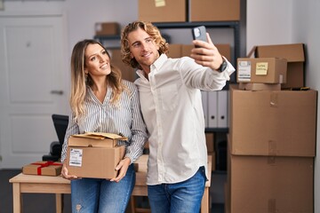 Man and woman ecommerce business workers make selfie by the smartphone at office