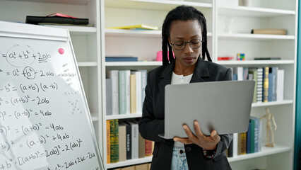 African american woman teacher teaching maths lesson using laptop at university classroom