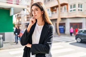 Fototapeta premium Young beautiful hispanic woman standing with doubt expression at street