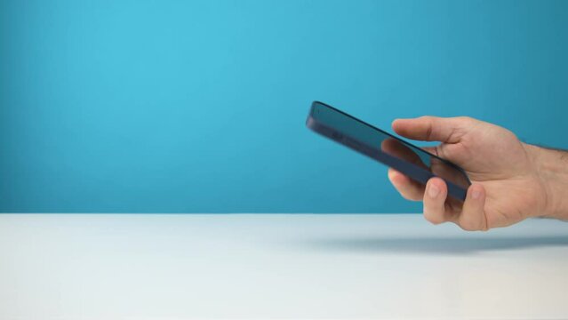 homme en train d'utiliser un smartphone dans sa main sur fond de studio