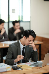 Businessmen feel stressed and tired sitting at his office with a laptop,mobbing concept