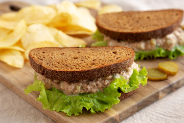 Homemade Tuna Sandwich with Lettuce on a wooden board, side view.