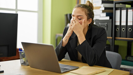 Young beautiful hispanic woman business worker stressed using laptop at office