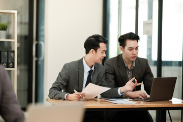 Group of business man discussion and brainstorming, bookkeeping audit graph and chart documents at desk, teamwork concept.