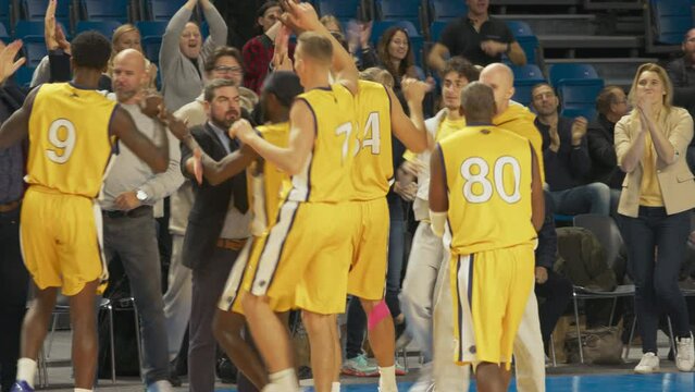 Happy Diverse Sports Team Winning Basketball Association Playoffs: Group of Players, Coaches, Managers, Friends and Fans Celebrate the Victory on Live Sports Broadcast Television Channel