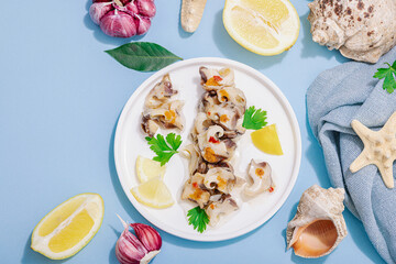 Pickled rapan meat with oil, spices and greens. Healthy seafood rich of omega