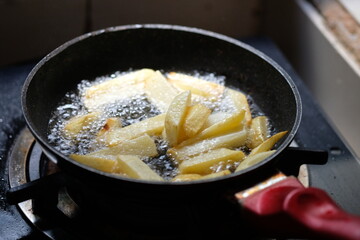 French fries in a black fryer. deep fryer. fried in hot palm oil. kentang goreng.