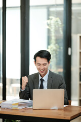 Fototapeta premium Young handsome asian businessman success working in the office looking to a computer.