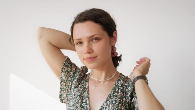 Portrait attractive cute brunette woman wear floral dress for romantic look. Details of everyday summer style. Looks young after 30s. Lady touching her hair and admiring herself. Looking at the camera