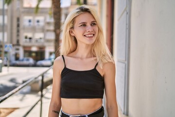 Fototapeta na wymiar Young blonde woman smiling confident looking to the side at street