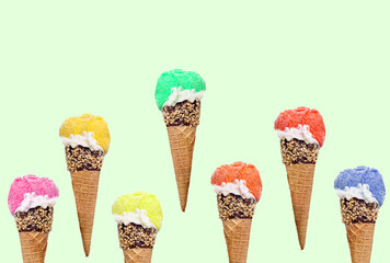 Ice cream in cone with chocolate and crushed nuts on green background. Summer dessert with different colors and taste, copy space.