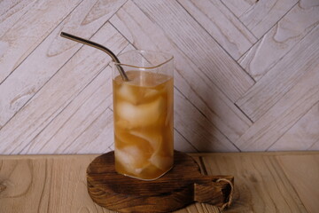 young coconut ice with brown sugar in a clear glass on a white wooden table. natural electrolyte....