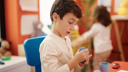 Adorable boy and girl playing with construction blocks at kindergarten