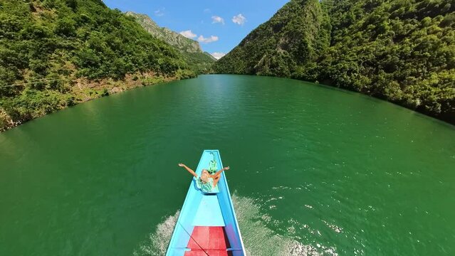 woman on the Shala River boat tour in Albania. Unique perspective, to explore remote areas inaccessible by land and discover the rich biodiversity that thrives in this pristine ecosystem.
