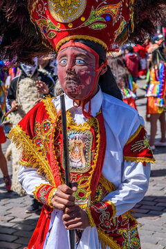 Cusco, a cultural fiesta, people dressed in traditional colourful costumes with masks and hats with feathers.