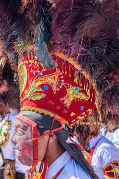 Cusco, a cultural fiesta, people dressed in traditional colourful costumes with masks and hats with feathers.