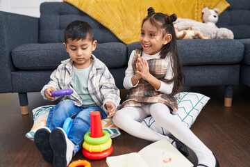 Adorable boy and girl clapping hands playing with hoops game at home