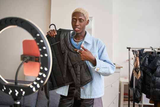 Emotional man fashion blogger recording new vlog about clothes